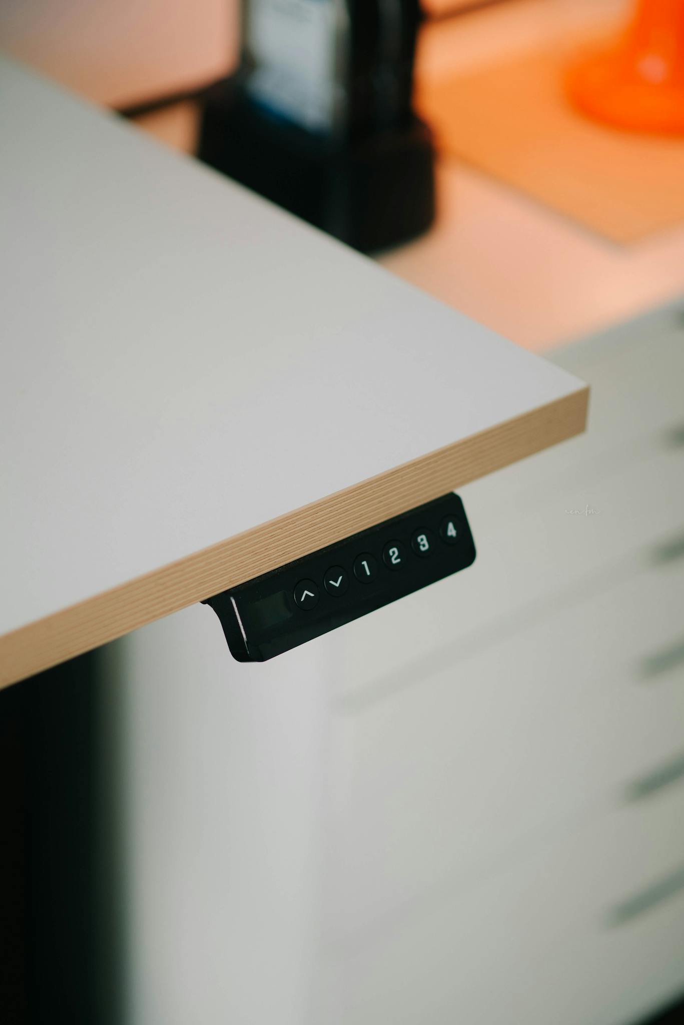 Close-up of a modern adjustable height desk with integrated control panel for height adjustment.